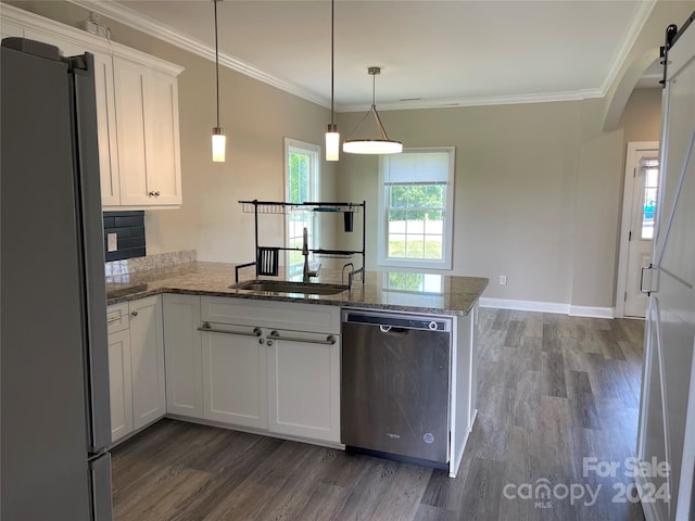 kitchen with appliances with stainless steel finishes, decorative light fixtures, white cabinetry, dark hardwood / wood-style floors, and kitchen peninsula