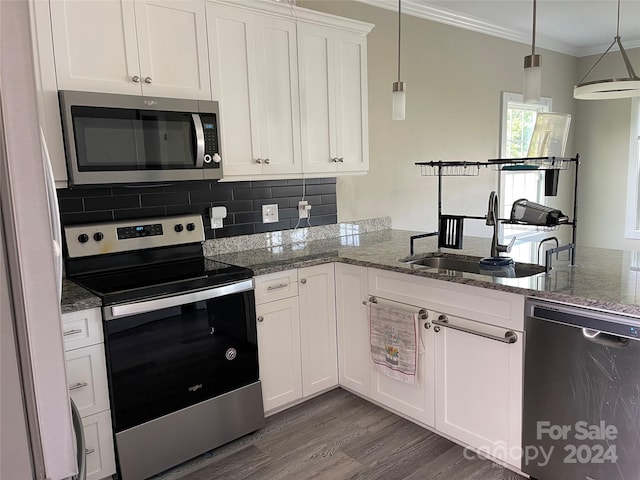 kitchen featuring white cabinets, stainless steel appliances, crown molding, and sink