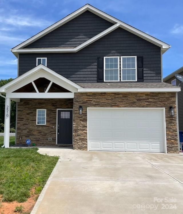 view of front of property with a front yard and a garage