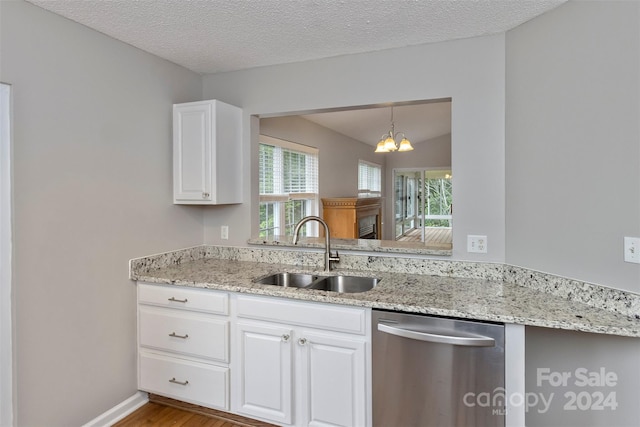 kitchen featuring a textured ceiling, dishwasher, white cabinetry, and sink