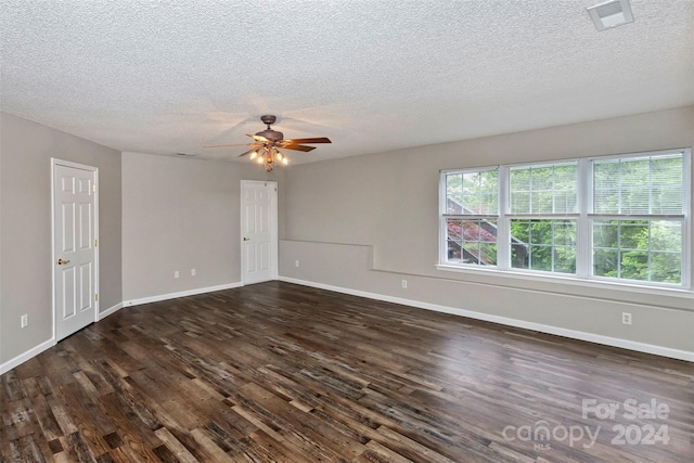 spare room featuring ceiling fan, dark hardwood / wood-style floors, and a textured ceiling