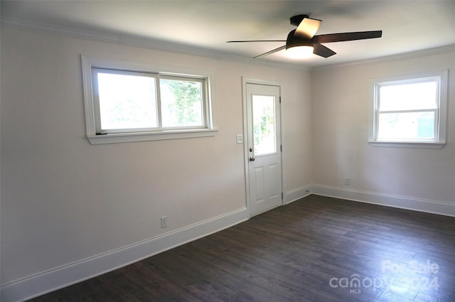 spare room with dark wood-type flooring, crown molding, and ceiling fan