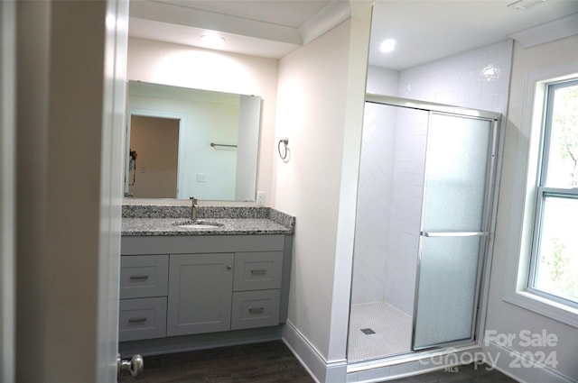 bathroom featuring wood-type flooring, an enclosed shower, and vanity