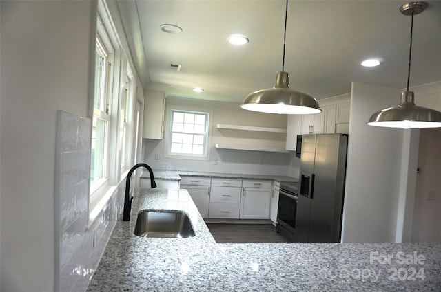 kitchen with decorative light fixtures, sink, white cabinetry, light stone countertops, and stainless steel appliances