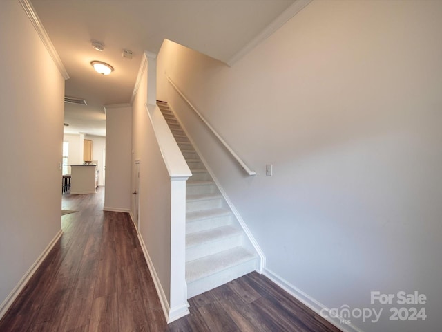 stairway with crown molding and hardwood / wood-style floors