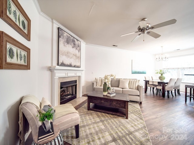 living room with ornamental molding, ceiling fan with notable chandelier, and hardwood / wood-style flooring