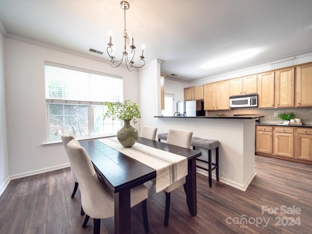 dining room with a chandelier, dark hardwood / wood-style flooring, and ornamental molding