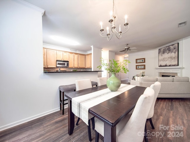 dining room featuring ceiling fan with notable chandelier, dark wood-type flooring, and ornamental molding