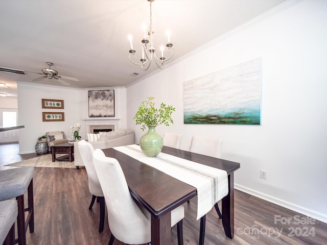 dining area featuring crown molding, ceiling fan with notable chandelier, and dark hardwood / wood-style floors