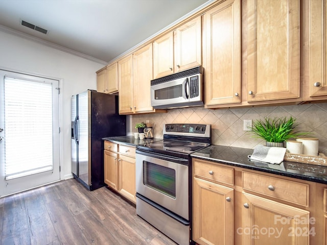 kitchen with backsplash, dark stone counters, ornamental molding, stainless steel appliances, and dark wood-type flooring