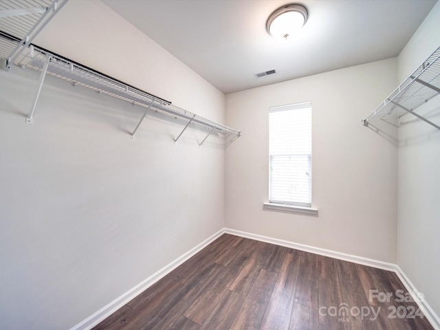 walk in closet with dark wood-type flooring