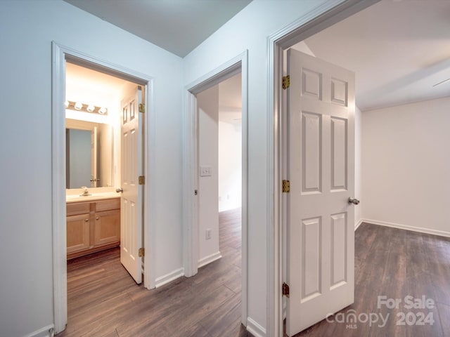 corridor with dark hardwood / wood-style floors and sink