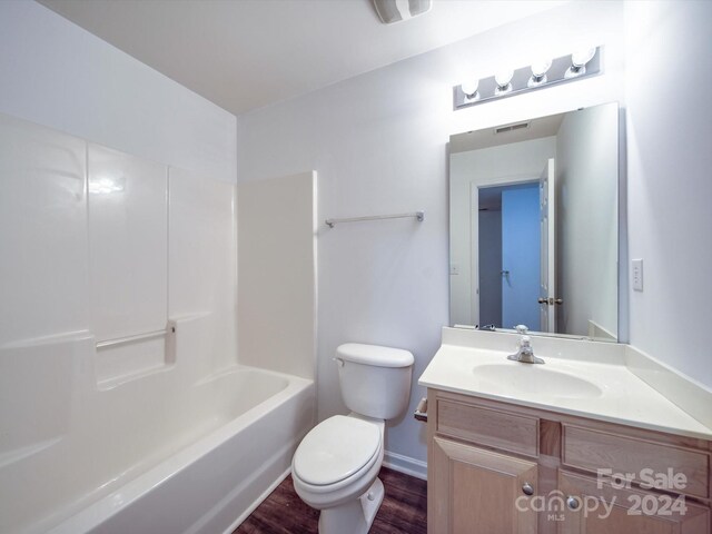 full bathroom with shower / bathing tub combination, vanity, hardwood / wood-style flooring, and toilet