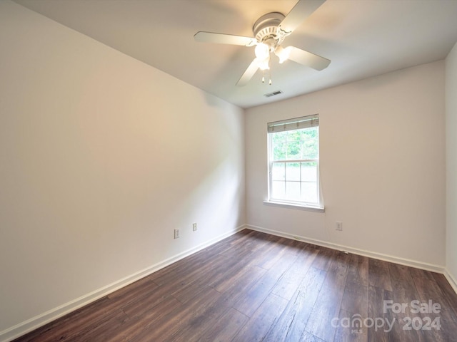 empty room with ceiling fan and dark hardwood / wood-style flooring