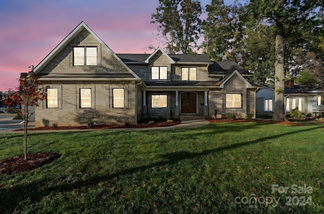 view of front of property with a yard and brick siding