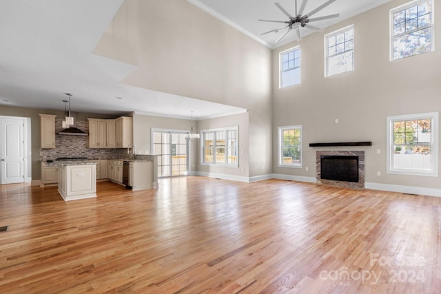 unfurnished living room with a wealth of natural light, light hardwood / wood-style flooring, and ornamental molding