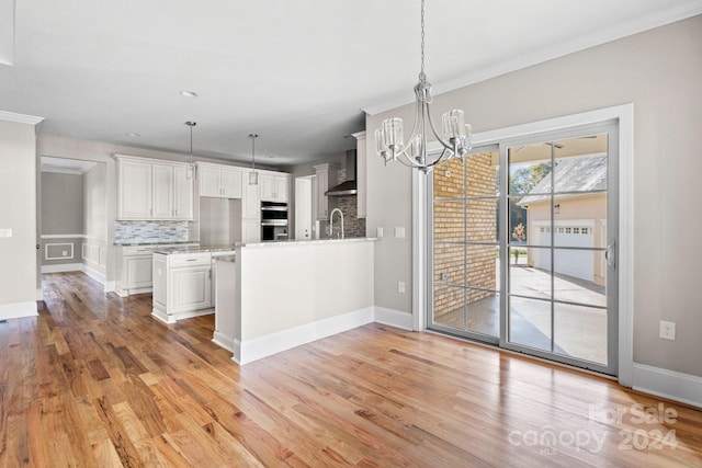 kitchen with white cabinets, decorative backsplash, decorative light fixtures, and kitchen peninsula