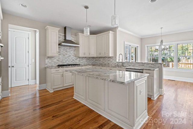 kitchen featuring white cabinetry, a center island, wall chimney range hood, and light wood-type flooring