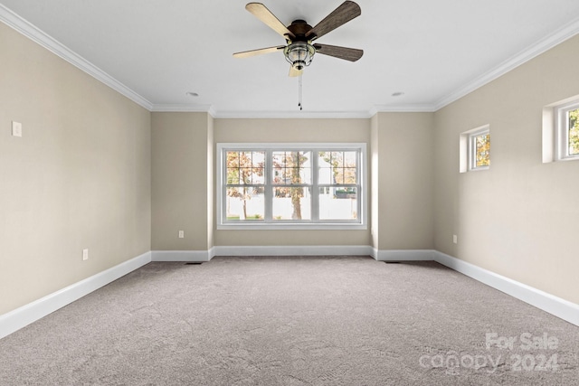 carpeted spare room with baseboards, ornamental molding, and a ceiling fan