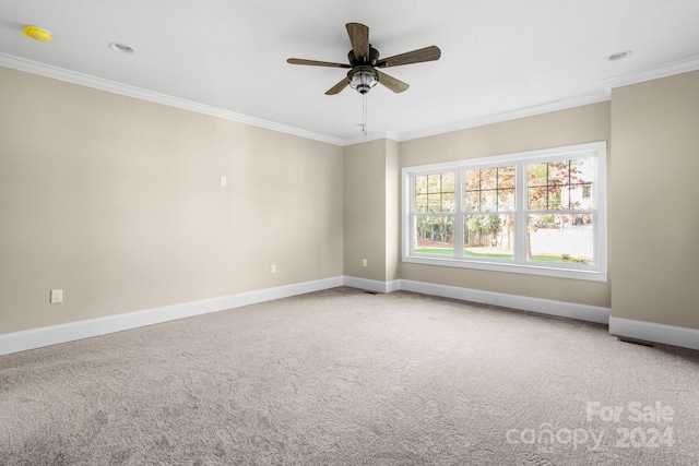 carpeted empty room featuring ornamental molding, baseboards, and ceiling fan