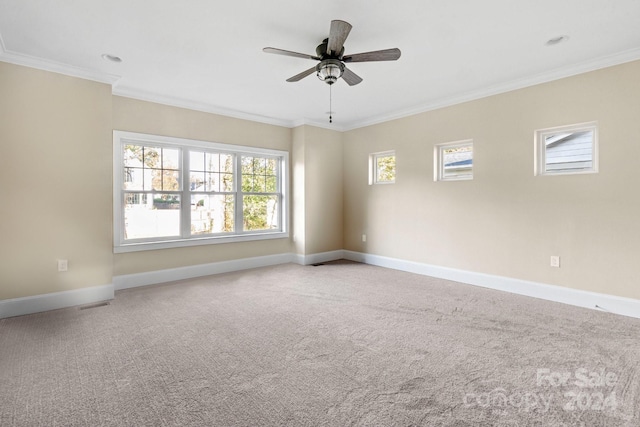 carpeted empty room featuring crown molding, a ceiling fan, and baseboards