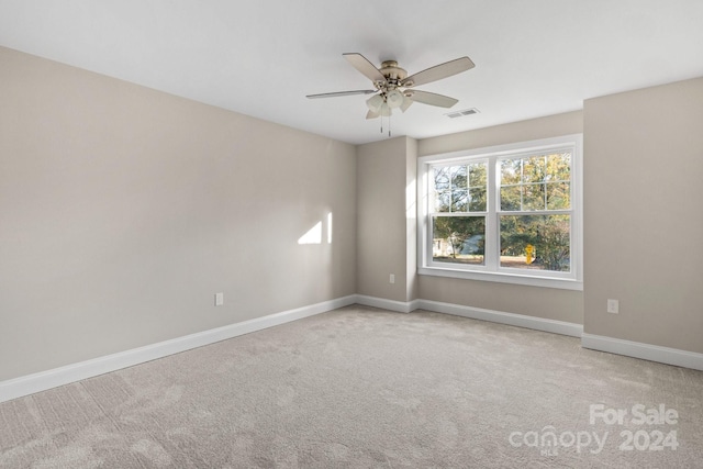 empty room featuring ceiling fan and light carpet