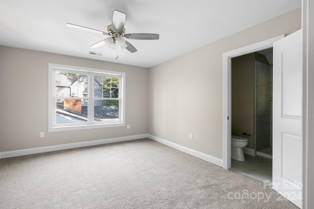 unfurnished bedroom featuring carpet floors, baseboards, ensuite bathroom, and a ceiling fan