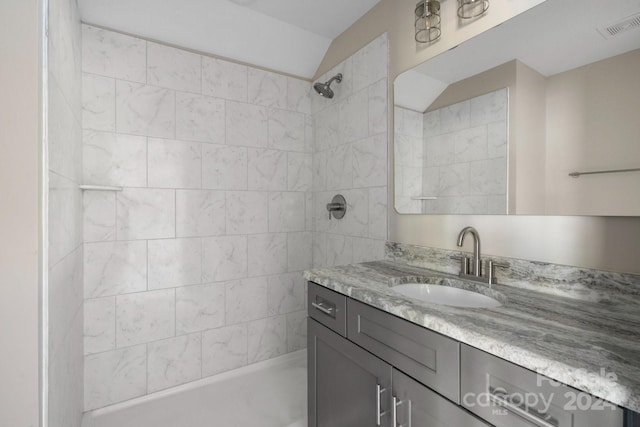 bathroom featuring a tile shower and vanity