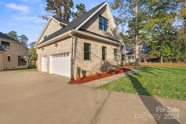view of property exterior featuring brick siding, driveway, and a lawn