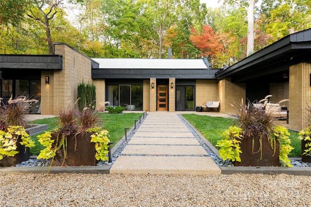 doorway to property with a lawn