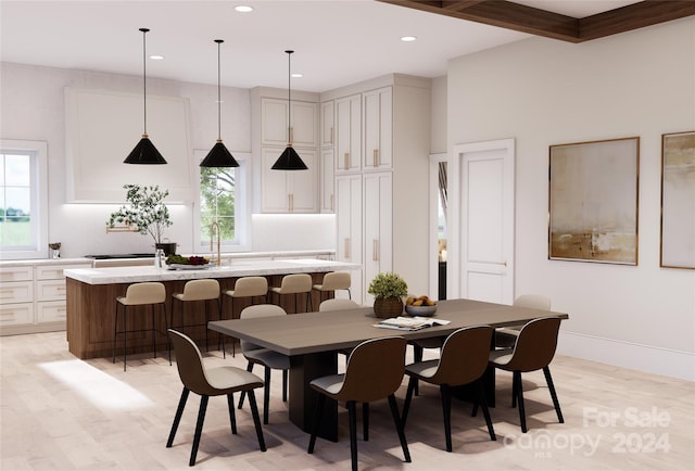 dining room with light hardwood / wood-style flooring and beamed ceiling