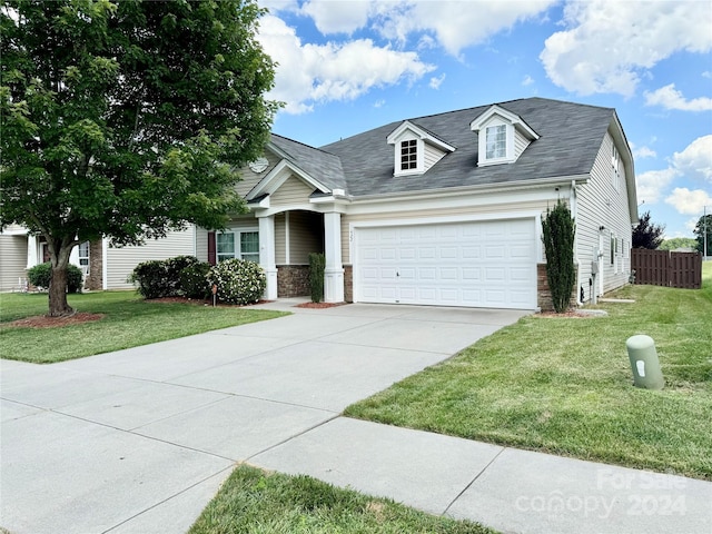 view of front of property featuring a front lawn and a garage