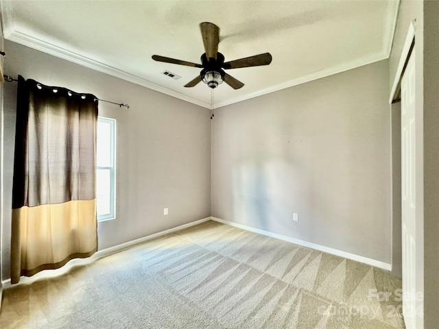 carpeted empty room featuring ceiling fan and crown molding