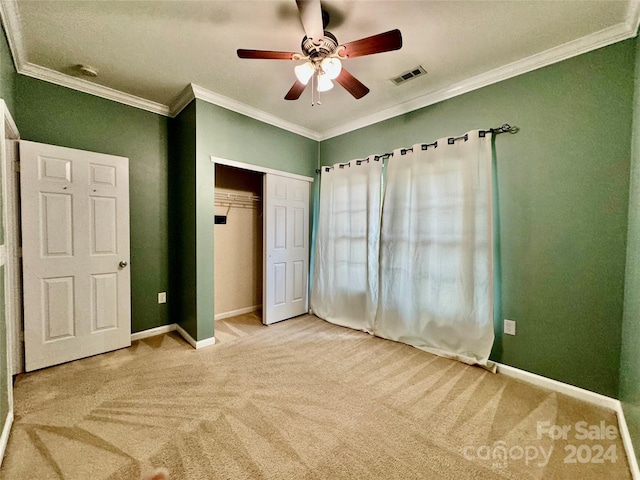 unfurnished bedroom with carpet, ceiling fan, ornamental molding, and a closet