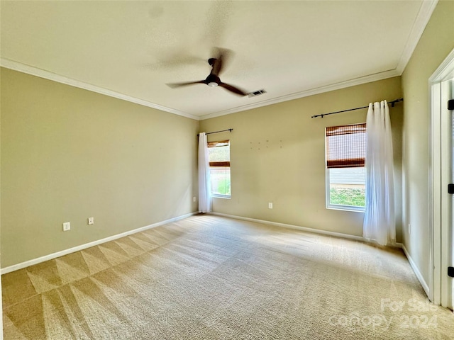 unfurnished room featuring a wealth of natural light, ceiling fan, light carpet, and ornamental molding