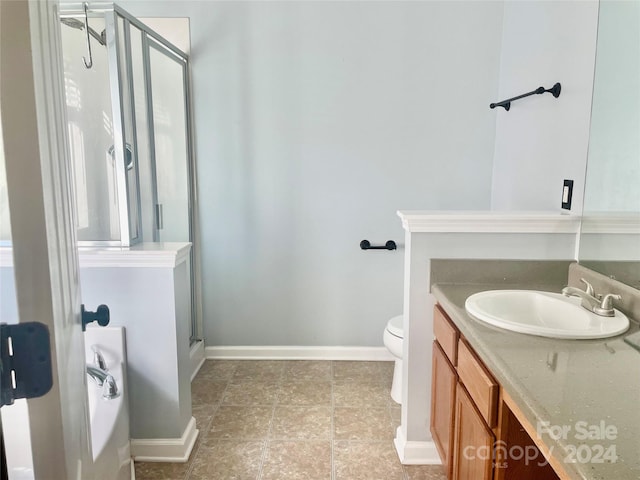 bathroom featuring vanity, toilet, and an enclosed shower