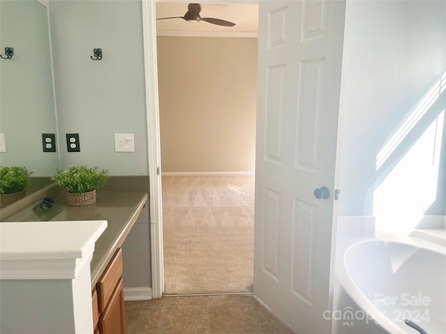 bathroom featuring tile patterned flooring, ceiling fan, crown molding, and vanity