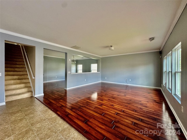 spare room with hardwood / wood-style flooring, an inviting chandelier, and crown molding