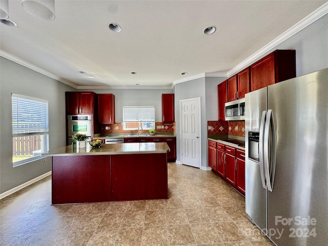 kitchen featuring decorative backsplash, appliances with stainless steel finishes, a kitchen island, and a wealth of natural light