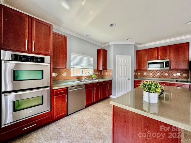 kitchen with backsplash, crown molding, sink, and appliances with stainless steel finishes