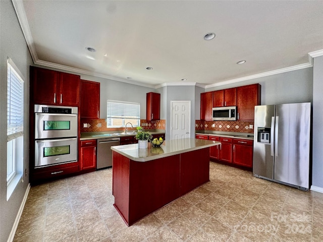 kitchen featuring backsplash, crown molding, a center island, and appliances with stainless steel finishes