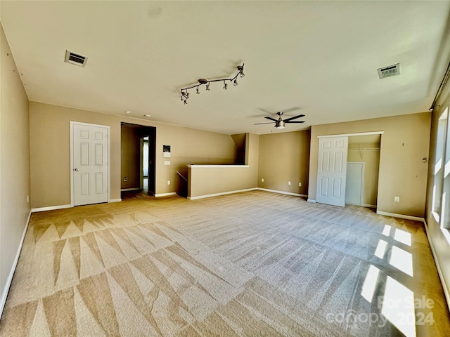 interior space with light carpet and rail lighting