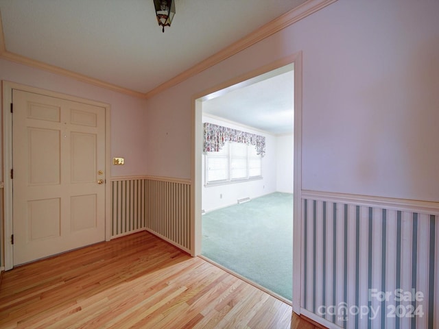 interior space featuring light wood-type flooring and crown molding