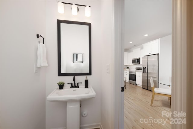 bathroom with backsplash and hardwood / wood-style floors