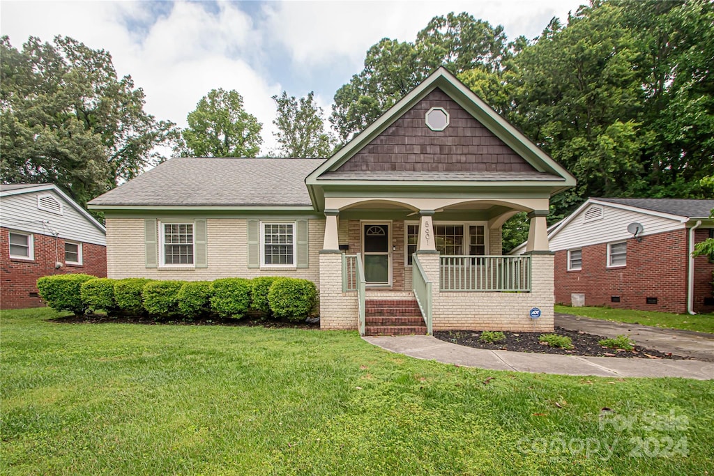 view of front of house featuring covered porch and a front lawn