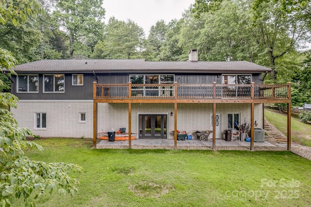 back of property with a patio, cooling unit, a deck, and a lawn