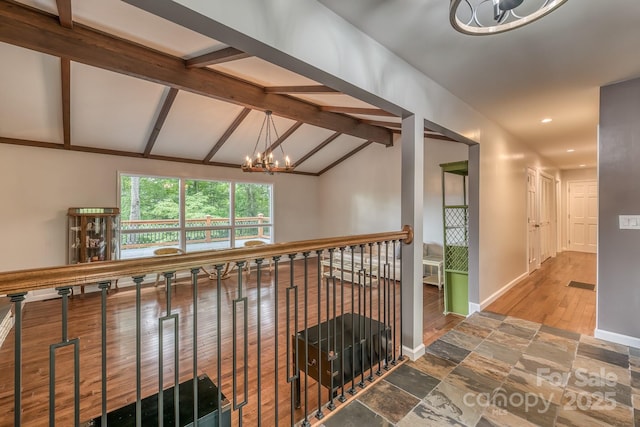 hall featuring lofted ceiling with beams and a chandelier