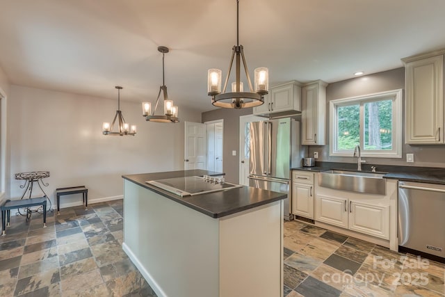 kitchen with sink, decorative light fixtures, a chandelier, a kitchen island, and stainless steel appliances