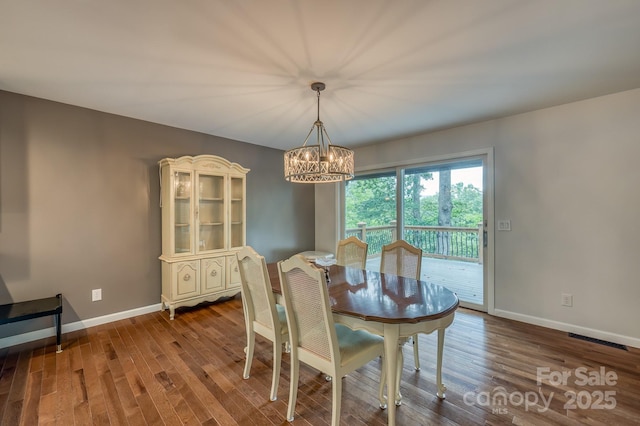 dining space with dark wood-type flooring and a chandelier