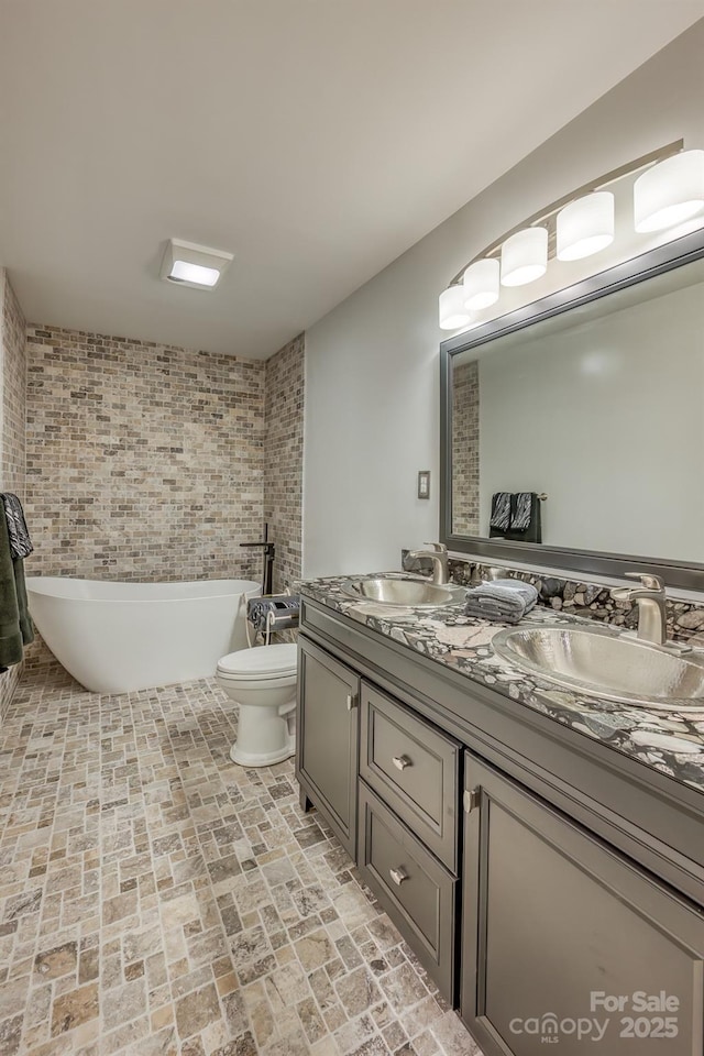 bathroom featuring vanity, a tub, and toilet